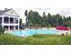 A community pool with lounge chairs and umbrellas provides a relaxing and social space for residents to enjoy at 201 Masterwood Way, Morrisville, NC 27560