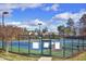 A well-maintained tennis court with lighting surrounded by fencing creates an ideal recreational amenity for sports enthusiasts at 201 Masterwood Way, Morrisville, NC 27560