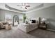 Bright bedroom boasts a tray ceiling, plush carpeting, and a cozy sitting area by the windows at 2060 Jersey City Pl, Apex, NC 27523