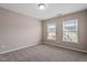 Neutral bedroom featuring two large windows and neutral carpeting at 2060 Jersey City Pl, Apex, NC 27523