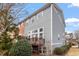 Side view of a grey home showing backyard deck, bushes, mulched garden, and various windows at 2060 Jersey City Pl, Apex, NC 27523