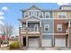 Charming two-story townhome featuring stone accents, a balcony, and individual garages at 2060 Jersey City Pl, Apex, NC 27523