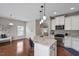 Bright kitchen featuring a granite island, stainless steel appliances, and hardwood floors at 2060 Jersey City Pl, Apex, NC 27523