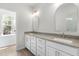 Bright bathroom featuring double vanity with stone countertops, white cabinetry, and arched mirrors at 2101 Wimberly Woods Dr, Sanford, NC 27330