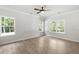 Bright bedroom featuring hardwood floors, three windows and white walls, creating a serene ambiance at 2101 Wimberly Woods Dr, Sanford, NC 27330