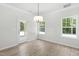 Well-lit dining area showcasing hardwood floors, a modern chandelier, and large windows at 2101 Wimberly Woods Dr, Sanford, NC 27330