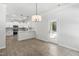 Dining area view leading to kitchen, featuring hardwood floors, modern pendant lights and rear exit at 2101 Wimberly Woods Dr, Sanford, NC 27330