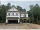 Two-story home featuring an attached garage and covered porch in a partially finished new construction at 2101 Wimberly Woods Dr, Sanford, NC 27330
