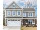 Charming two-story home featuring a gray facade, stone accents, and a welcoming front porch at 2101 Wimberly Woods Dr, Sanford, NC 27330