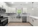 Bright kitchen features white cabinets, stainless appliances, quartz counters, and wood grain flooring at 2101 Wimberly Woods Dr, Sanford, NC 27330
