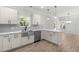 This bright kitchen features stainless steel appliances, gray backsplash, wood-look flooring, and view to backyard at 2101 Wimberly Woods Dr, Sanford, NC 27330
