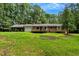 Rear view of the home with a wooden deck and lush green yard at 224 Oakcrest Dr, Wake Forest, NC 27587