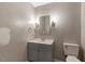 Cozy half-bath features a modern vanity with storage, decorative mirror, and sleek fixtures at 224 Oakcrest Dr, Wake Forest, NC 27587