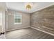 Bedroom showcasing gray laminate flooring, natural light, and decorative wood wall at 224 Oakcrest Dr, Wake Forest, NC 27587