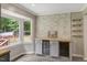 Stylish dining area with built-in wine storage, stone accent wall, and sunny bay window at 224 Oakcrest Dr, Wake Forest, NC 27587