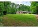 View of the ranch-style home featuring a welcoming front porch, carport, and sprawling green lawn at 224 Oakcrest Dr, Wake Forest, NC 27587