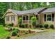Charming home featuring a cozy front porch with lovely landscaping including flowers and shrubbery at 224 Oakcrest Dr, Wake Forest, NC 27587