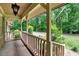 Charming covered front porch with wood railing offers a relaxing outdoor space with lush landscaping at 224 Oakcrest Dr, Wake Forest, NC 27587
