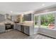 Beautifully updated kitchen with gray cabinets, stainless appliances, and a large window with wooded views at 224 Oakcrest Dr, Wake Forest, NC 27587