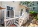 Cozy back deck featuring white railings, a grill, and access to the home's interior and the brick-paved yard at 225 Vance St, Chapel Hill, NC 27516