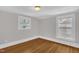 Bedroom showcasing gleaming hardwood floors and abundant natural light from two windows at 225 Vance St, Chapel Hill, NC 27516