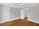 Bedroom featuring hardwood floors, neutral walls, and classic white doors with traditional trim at 225 Vance St, Chapel Hill, NC 27516