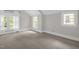 Bright bedroom featuring three windows offering ample natural light and neutral carpeting at 225 Vance St, Chapel Hill, NC 27516