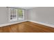 Inviting bedroom featuring gleaming hardwood floors and natural light streaming through a large window at 225 Vance St, Chapel Hill, NC 27516