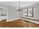 Bright dining room featuring hardwood floors, a chandelier, and natural light from large windows at 225 Vance St, Chapel Hill, NC 27516