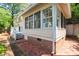 Rear exterior view showcasing a brick-paved area, part of a deck, and the home's siding with multiple windows at 225 Vance St, Chapel Hill, NC 27516