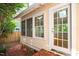 Rear exterior of the home showing a white-framed glass door, a section of brick-paved yard, and multiple windows at 225 Vance St, Chapel Hill, NC 27516