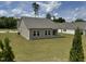 Wide view of the backyard showing manicured lawn, vinyl siding, and neighboring houses at 23 Rolling Banks Dr, Louisburg, NC 27549