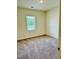 Bright bedroom featuring neutral carpeting, a large window, and ample natural light at 23 Rolling Banks Dr, Louisburg, NC 27549