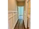 Hallway with wooden floors, board and batten detailing, and laundry room access at 23 Rolling Banks Dr, Louisburg, NC 27549