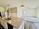 Modern kitchen island with granite countertops and stainless appliances open to the great room at 23 Rolling Banks Dr, Louisburg, NC 27549