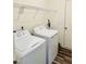 Functional laundry room equipped with a washer, dryer, and storage shelving at 23 Rolling Banks Dr, Louisburg, NC 27549