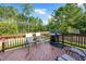 Relaxing deck featuring a grill and chairs overlooking a backyard surrounded by lush trees at 232 Randleman Ct, Holly Springs, NC 27540