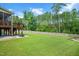 Expansive backyard with lush lawn, mature trees, privacy fence, and basketball hoop at 232 Randleman Ct, Holly Springs, NC 27540