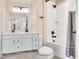 Dual image showcasing modern bathroom with a white vanity and tiled tub/shower combination at 232 Randleman Ct, Holly Springs, NC 27540