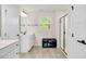 Spacious bathroom with double doors, white vanity, glass shower, and window view at 232 Randleman Ct, Holly Springs, NC 27540