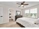 Inviting bedroom with a ceiling fan, window, and adjacent bathroom, offering comfort and style at 232 Randleman Ct, Holly Springs, NC 27540