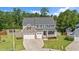 Inviting two-story home featuring a two-car garage, stone accents, and a cozy front porch at 232 Randleman Ct, Holly Springs, NC 27540