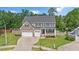 Charming two-story home with stone accents, a two-car garage, and a welcoming front porch at 232 Randleman Ct, Holly Springs, NC 27540