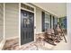 Charming front porch with rocking chairs, wooden accents, and a welcoming front door at 232 Randleman Ct, Holly Springs, NC 27540