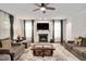 Spacious living room with a fireplace, plush sofas, a ceiling fan and large windows with sheer curtains at 232 Randleman Ct, Holly Springs, NC 27540