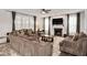 Spacious living room with a fireplace, plush sofas, a ceiling fan and large windows with sheer curtains at 232 Randleman Ct, Holly Springs, NC 27540