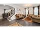 Elegant living room featuring hardwood floors, comfortable sofas, and decorative lighting fixtures and view to staircase at 232 Randleman Ct, Holly Springs, NC 27540