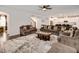 Spacious living room with plush sofas, a ceiling fan, and view to staircase and kitchen with breakfast bar at 232 Randleman Ct, Holly Springs, NC 27540