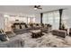 Spacious living room featuring a large sectional sofa, patterned rug, and abundant natural light from the large windows at 232 Randleman Ct, Holly Springs, NC 27540