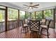Cozy screened porch with a ceiling fan and a round table surrounded by comfortable chairs, perfect for outdoor dining at 232 Randleman Ct, Holly Springs, NC 27540
